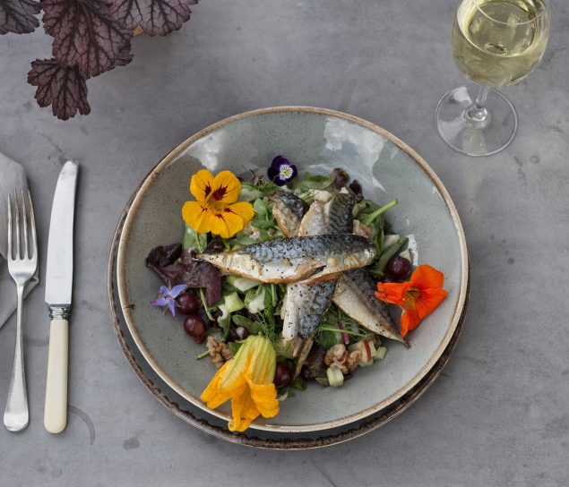 Plate of food at the Duchy Nursery with fresh fish and edible flowers from the garden.