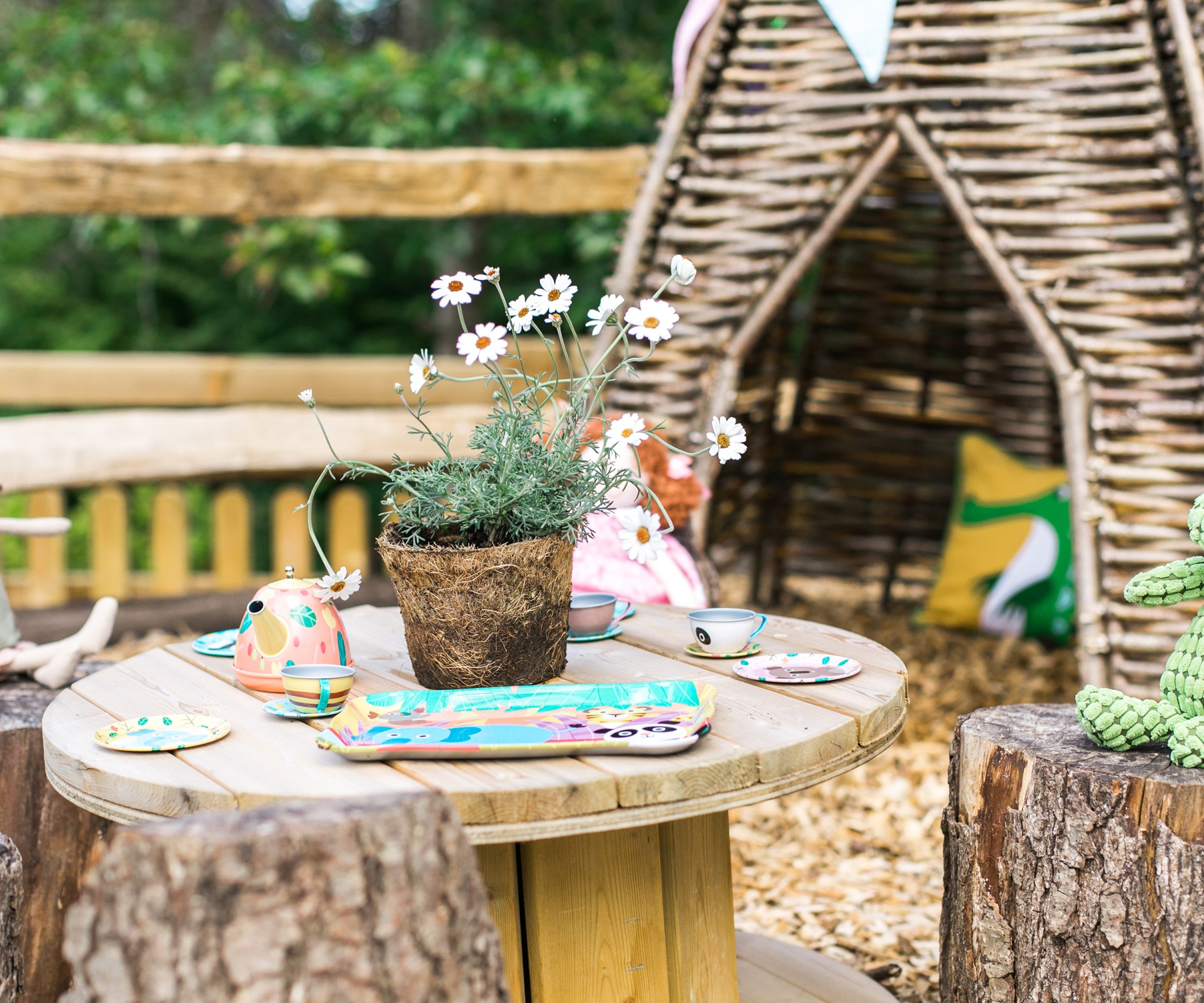 Handmade wooden miniature seating area and children's toys.